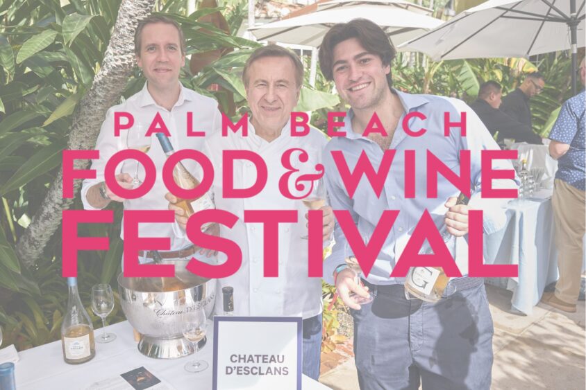 Three men stand behind a wine display table outdoors at the Palm Beach Food & Wine Festival, smiling and holding bottles. Large pink text with the event name overlays the image—a perfect snapshot for any Palm Beach Weekend Guide. Lifestyle
