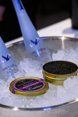 An open tin of black caviar and two bottles of Grey Goose vodka are chilling on a bed of ice in a metal bowl—after hours done right. Lifestyle