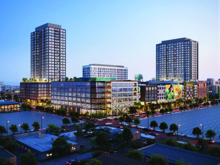 A modern Fort Lauderdale cityscape at dusk featuring two tall apartment towers and a mid-rise with glass windows, rooftop greenery, and a mural. Busy Fat Village streets and trees line the foreground, with water visible at the bottom. Lifestyle