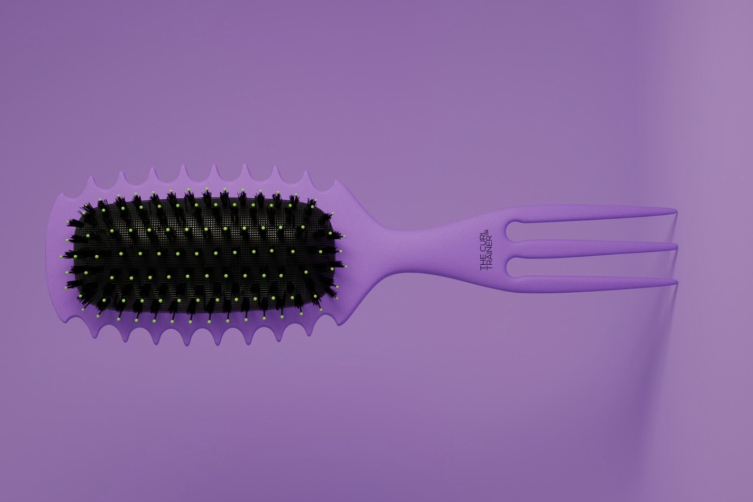 A purple hairbrush with black bristles and yellow tips, featuring a unique wavy edge and a handle that splits into two prongs, placed on a matching purple background. Lifestyle