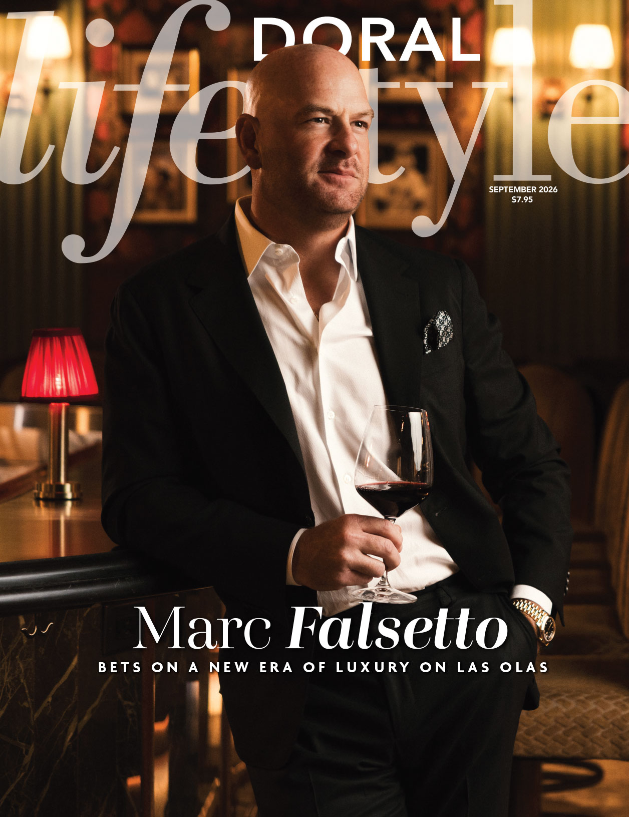 A bald man in a suit holds a glass of wine while leaning on a bar in a dimly lit, upscale lounge. The text reads: “Doral Lifestyle, Marc Falsetto bets on a new era of luxury on Las Olas—coming September 2026.”. Lifestyle