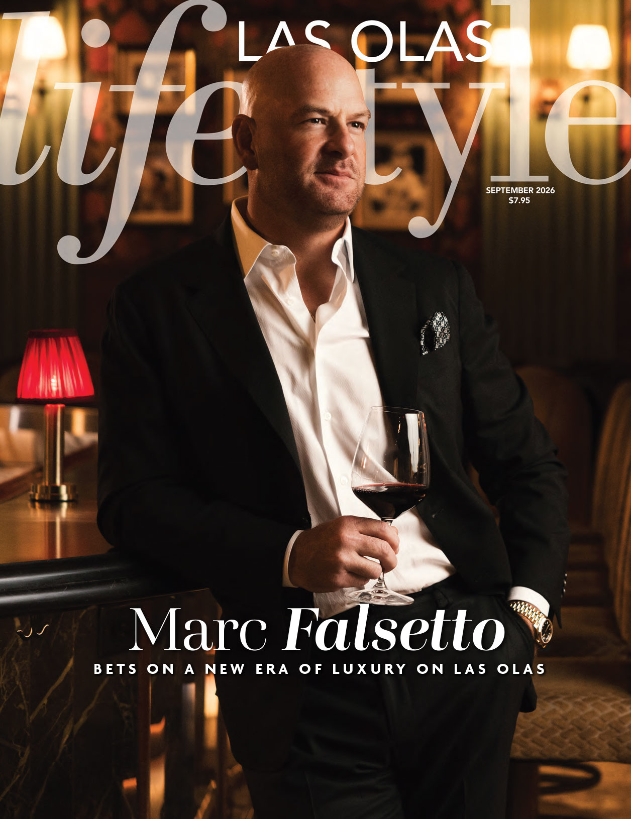 A man in a black suit holds a wine glass while sitting in a dimly lit, elegant bar featured on the cover of Las Olas Lifestyle magazine, September 2020 issue. Lifestyle